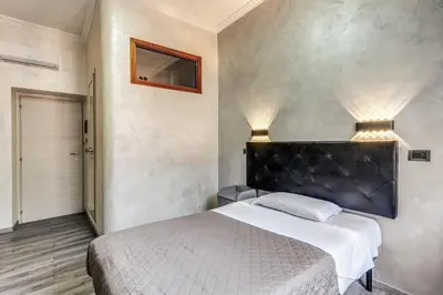 a bedroom with a large bed with a black headboard at Hotel Planet in Rome