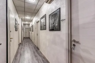 a corridor of a hallway with paintings on the walls at Hotel Planet in Rome