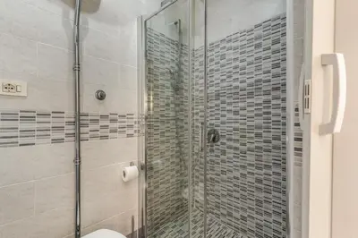 a bathroom with a glass shower with a toilet at Hotel Planet in Rome