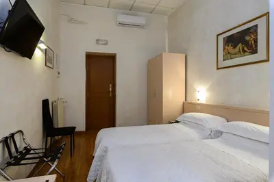 a hotel room with two beds and a flat screen tv at Hotel Julia Trevi - Spagna in Rome