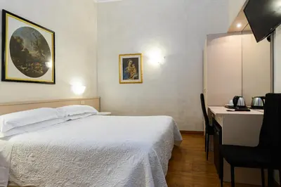 a bedroom with a bed and a desk and a table at Hotel Julia Trevi - Spagna in Rome