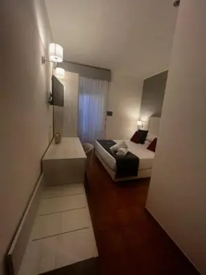 a small room with two beds and a bathroom at Hotel Gabriella in Rome