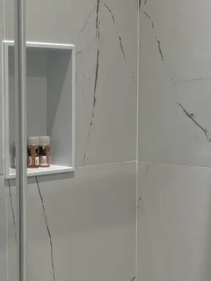 a bathroom with a white cabinet with marble walls at Hotel Gabriella in Rome