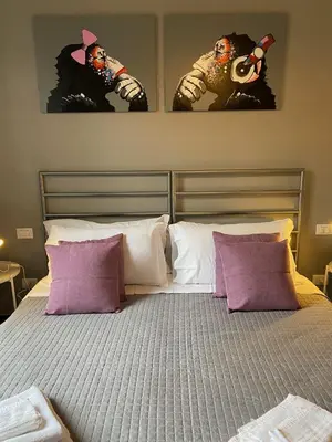 a bed with three pictures on the wall above it at Guest House Rome by GHOR in Rome