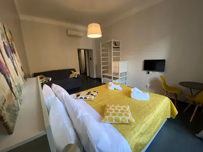 a room with a table with a yellow table cloth at Guest House Rome by GHOR in Rome