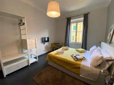 a small bedroom with a bed with a yellow blanket at Guest House Rome by GHOR in Rome