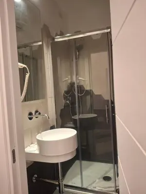 a bathroom with a sink and a glass shower at Hotel Viennese in Rome