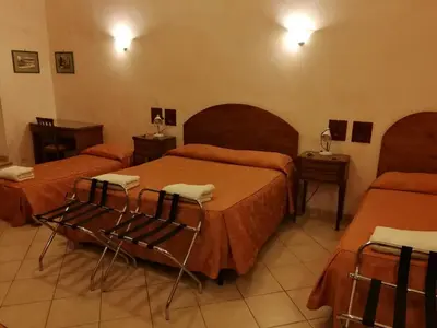 a hotel room with three beds and two chairs at Casa Zavatti in Rome