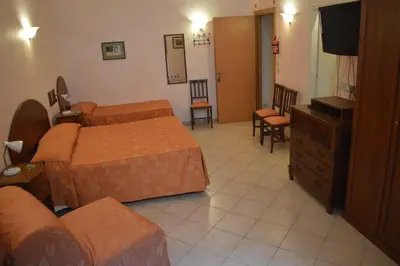 a hotel room with two beds and a television at Casa Zavatti in Rome