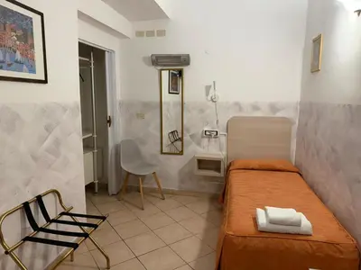 a small room with a bed and a chair at Casa Zavatti in Rome