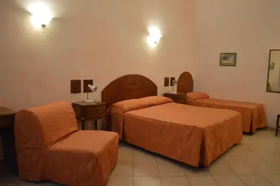 a hotel room with two beds and a chair at Casa Zavatti in Rome