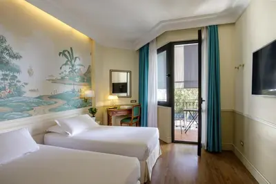 a hotel room with two beds and a balcony at Donna Laura Palace by OMNIA hotels in Rome