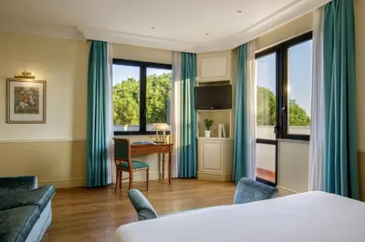 a hotel room with a bed and a desk at Donna Laura Palace by OMNIA hotels in Rome