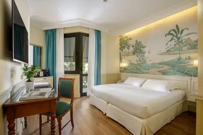 a hotel room with a bed and a desk and a desk at Donna Laura Palace by OMNIA hotels in Rome