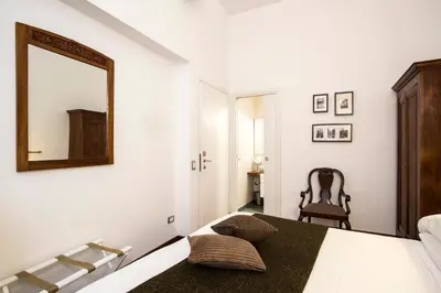a bedroom with a mirror and a bed and a chair at B&B Arco Del Lauro in Rome