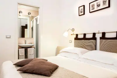 a white bedroom with a bed and a sink at B&B Arco Del Lauro in Rome