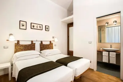 two beds in a bedroom with a sink and a mirror at B&B Arco Del Lauro in Rome