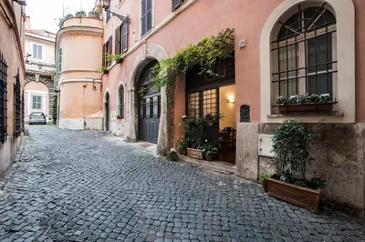 an empty street in an old town with flowers in windows at B&B Arco Del Lauro in Rome