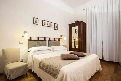 a bedroom with a large bed and a chair at B&B Arco Del Lauro in Rome