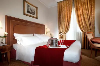 a hotel room with a large bed with a red table at Pinewood Hotel Rome in Rome