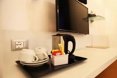 a counter with a coffee maker and cups on it at Hotel Franklin Feel The Sound in Rome