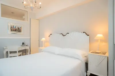 a white bedroom with a white bed and a desk at Sotto La Cupola in Rome