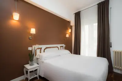 a bedroom with a white bed and a window at Sotto La Cupola in Rome