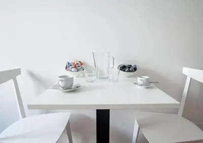 a white table with two chairs and two cups at Sotto La Cupola in Rome