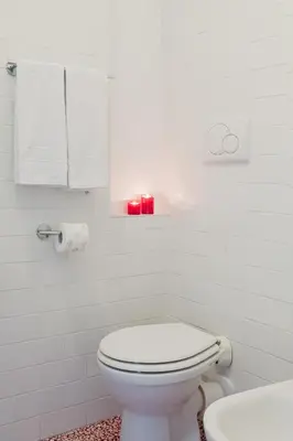 a white bathroom with a toilet and a sink at Sotto La Cupola in Rome