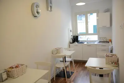 a kitchen with two tables and chairs and a sink at Sotto La Cupola in Rome