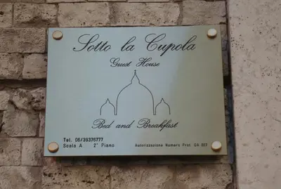 a sign on a brick wall with a wedding invitation at Sotto La Cupola in Rome