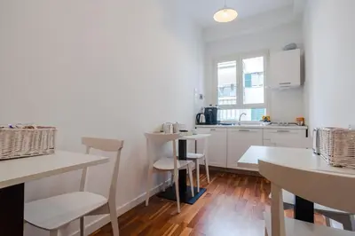a kitchen with white counters and white tables and chairs at Sotto La Cupola in Rome