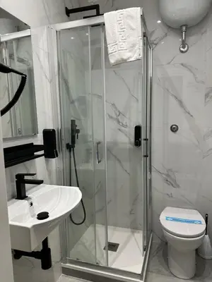 a bathroom with a shower and a toilet and a sink at Hotel Sol Levante in Rome
