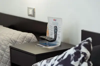 a box and a remote control on a table next to a bed at Hotel Sol Levante in Rome
