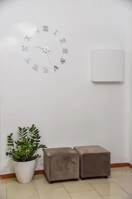 a clock on a wall with a bench and a plant at Hotel Sol Levante in Rome
