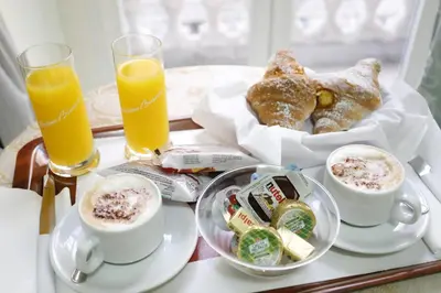 a tray with a breakfast of coffee and croissants and orange juice at Hotel Sol Levante in Rome