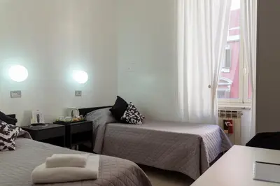 a hotel room with two beds and a window at Hotel Sol Levante in Rome
