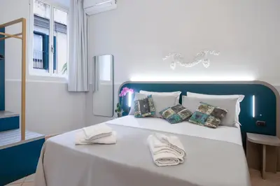 a large white bed with two white towels on it at Hotel Grifo in Rome