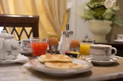 a table with a plate of breakfast foods and drinks at Hotel Grifo in Rome