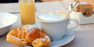 a cup of coffee and croissants on a table at Hotel Gabriele in Rome