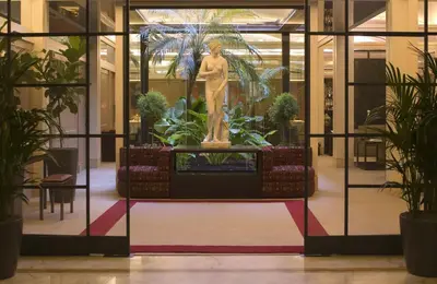 a statue of a woman in a room with plants at Hotel dei Borgognoni in Rome