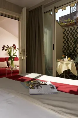 a room with a bed with a magazine on it at Hotel dei Borgognoni in Rome