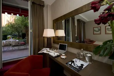 a hotel room with a desk and a mirror at Hotel dei Borgognoni in Rome