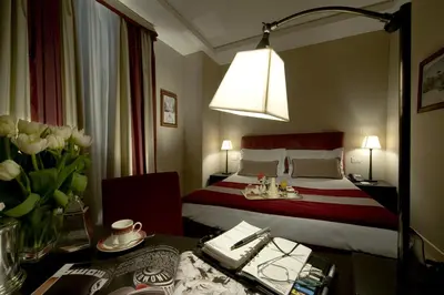 a hotel room with a bed and a table with flowers at Hotel dei Borgognoni in Rome
