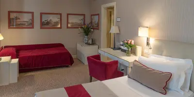 a hotel room with a bed and a red couch at Hotel dei Borgognoni in Rome