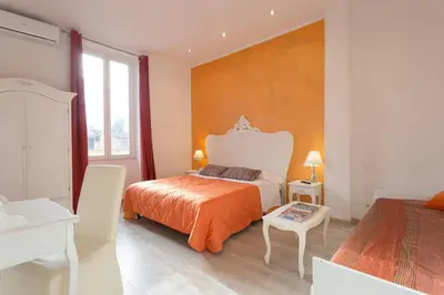 a bedroom with a bed with an orange bedspread at Colosseo Apartments and Rooms - Rome City Centre in Rome