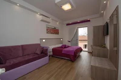 a living room with a couch and a bed at Colosseo Apartments and Rooms - Rome City Centre in Rome