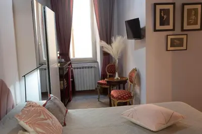 a bedroom with a bed and a table and a window at Boutique Grifone in Rome