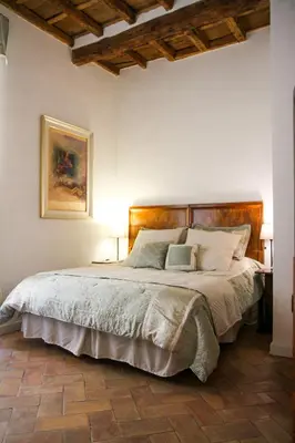 a bedroom with a large bed with a wooden headboard at Boutique Grifone in Rome