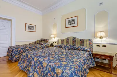a hotel room with a bed and a chair at Hotel Cellini in Rome